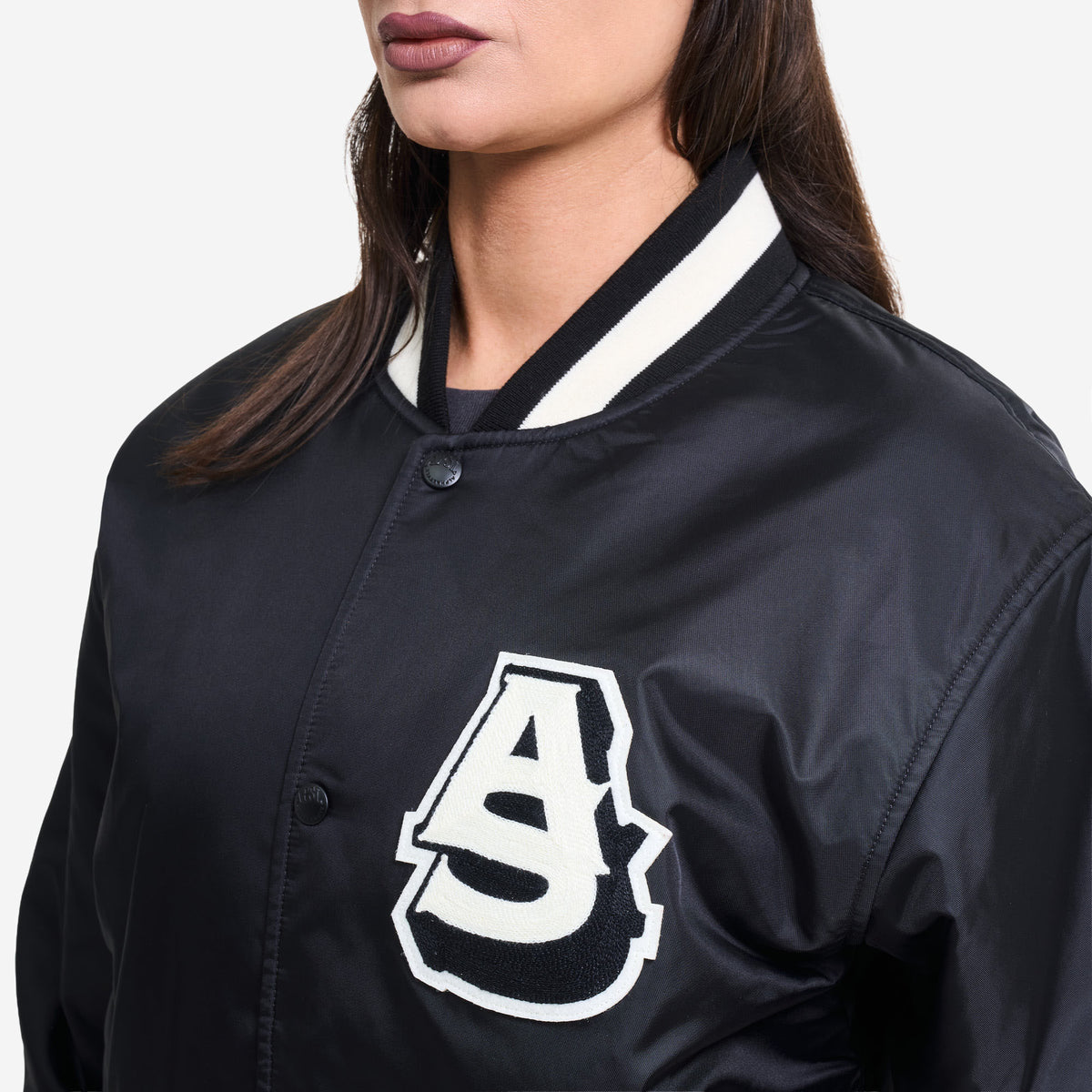 AlphaStyle Barren Varsity Jacket in Black – Nahaufnahme am Model mit AS-Chenille-Patch und Kontrastkragen