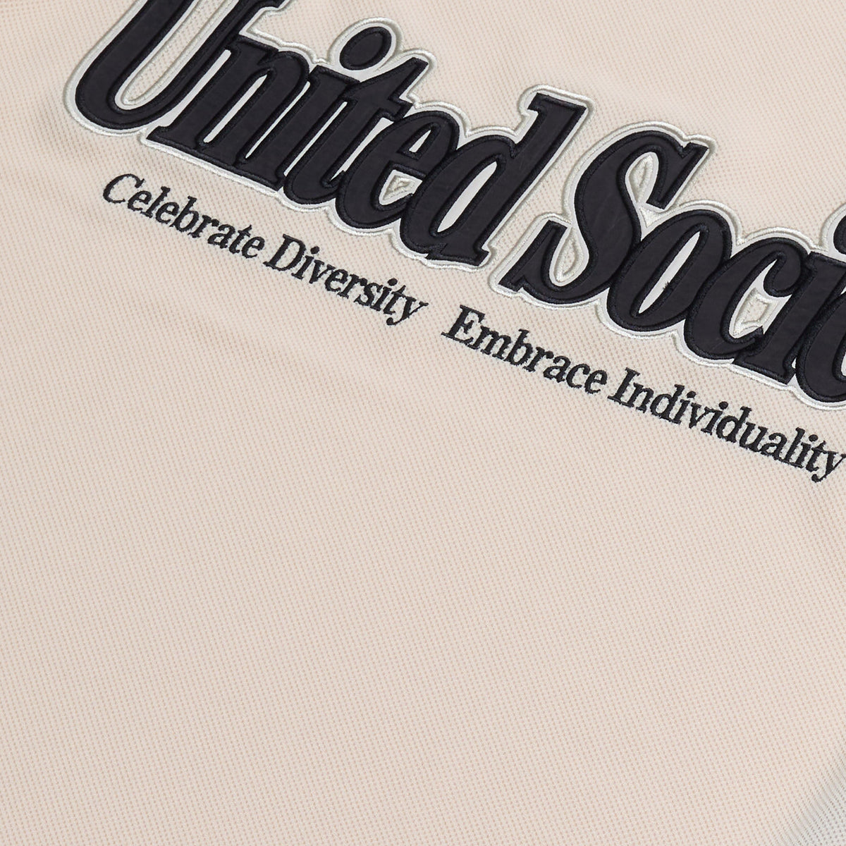 AlphaStyle Reyes Soccer Jersey in Bone – Detailaufnahme des gestickten United-Society-Schriftzugs mit dem Zusatz Celebrate Diversity, Embrace Individuality