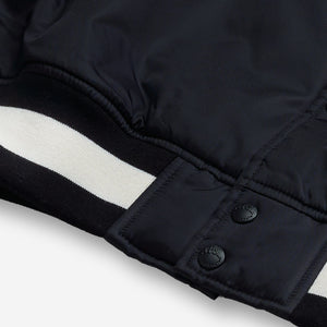 AlphaStyle Barren Varsity Jacket in Black – Detailaufnahme von Saumbund und Druckknopfleiste mit schwarz-weißem Rippstrick
