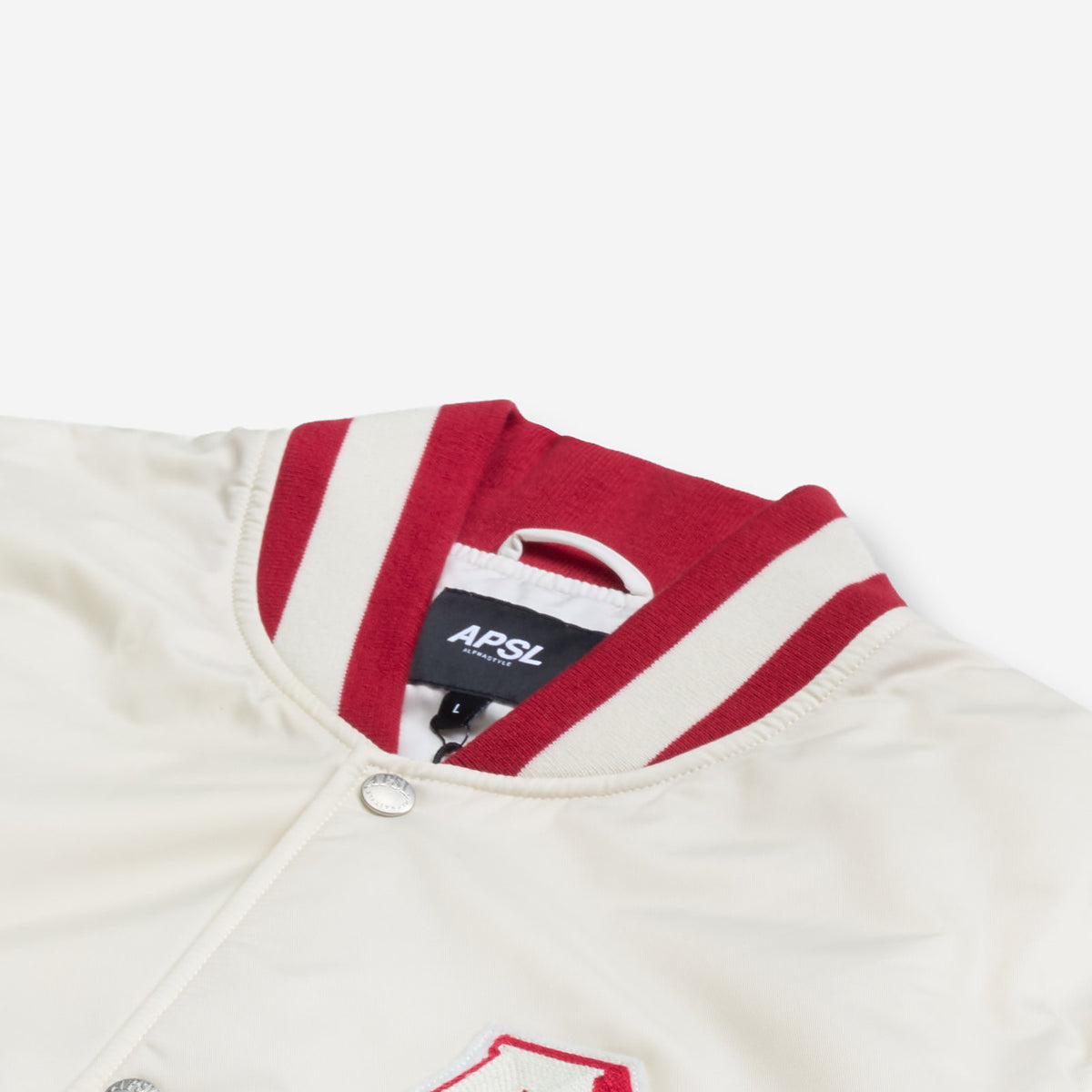 AlphaStyle Barren Varsity Jacket in Bone – Detailaufnahme von Kragen, Druckknopf und eingenähtem APSL-Label