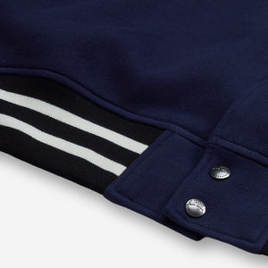 AlphaStyle Ritch Logo Baseball Jacket in Navy/Denim – Detailaufnahme des schwarz-weiß gestreiften Saumbunds mit Druckknöpfen