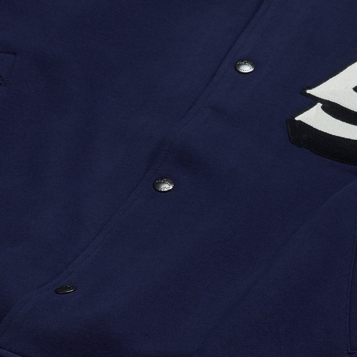 AlphaStyle Ritch Logo Baseball Jacket in Navy/Denim – Detailaufnahme der Druckknopfleiste auf dem Navy-Baumwollkörper