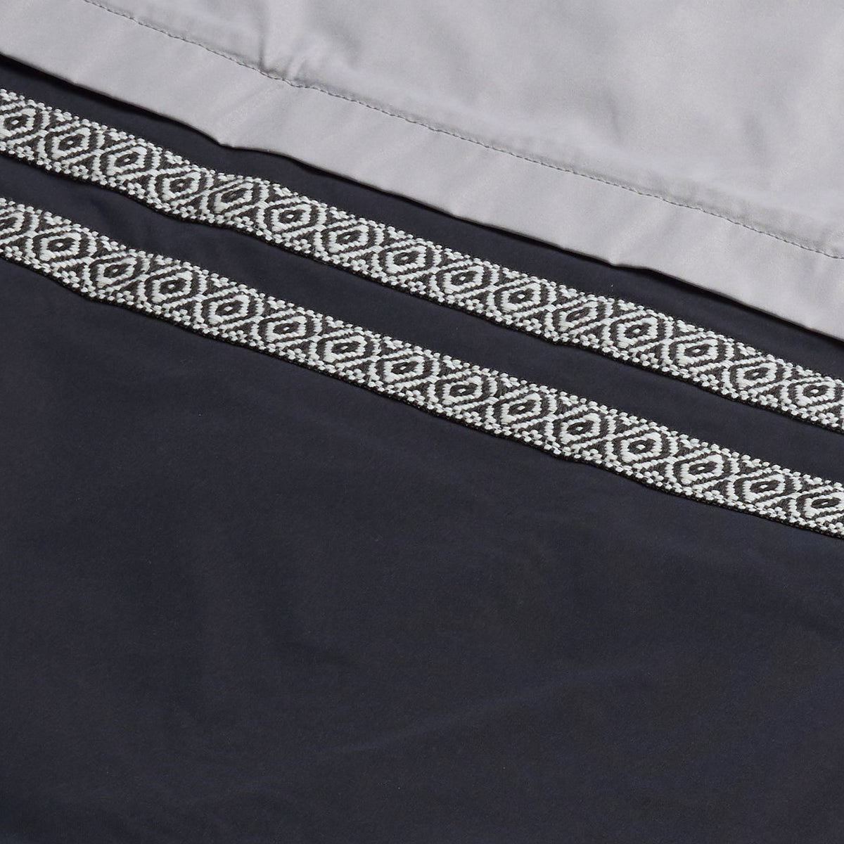 AlphaStyle Whitman Batwing Windbreaker Jacket in Black/Grey – Detailaufnahme des gewebten Aztec-Zierbands auf schwarzem Nylon