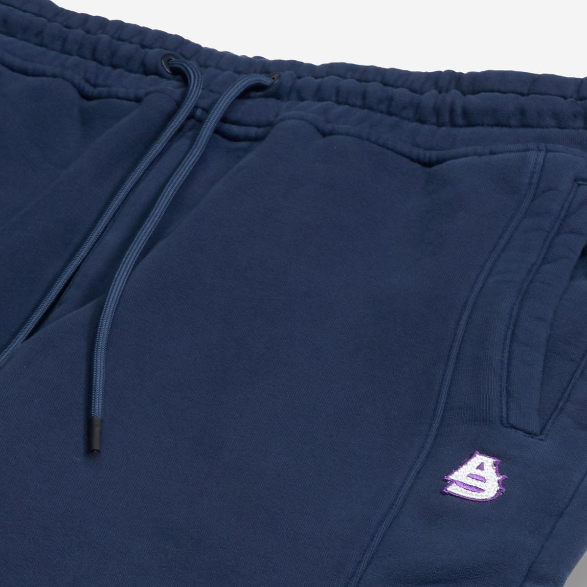 AlphaStyle Tybee Zip Vent Track Pants in Navy – Detailaufnahme des Kordelzug-Bunds mit rosa AS-Stickerei