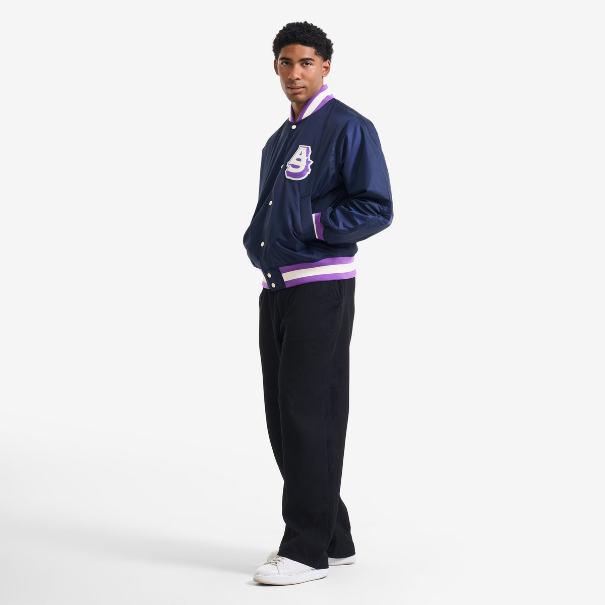 AlphaStyle Barren Varsity Jacket in Navy – Seitliche Ganzkörperaufnahme am Model zu schwarzer weiter Hose