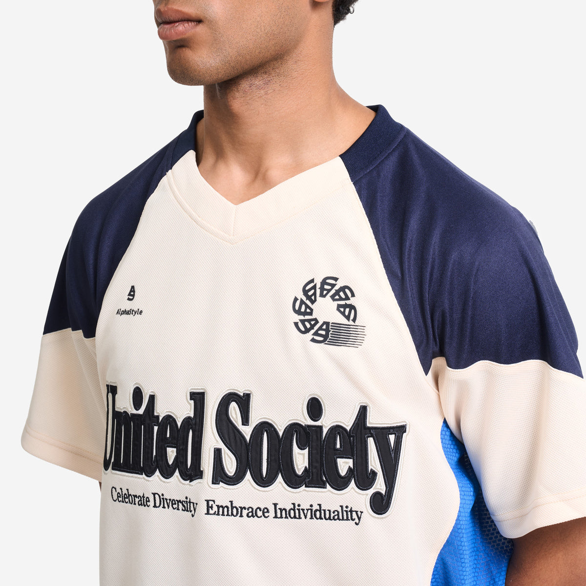 AlphaStyle Reyes Soccer Jersey in Bone – Nahaufnahme am Model mit V-Ausschnitt, gesticktem Wappen und United-Society-Schriftzug