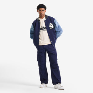 AlphaStyle Gale Baggy Convertible Pants in Navy – Ganzkörperaufnahme am Model, kombiniert mit Varsity-Jacke