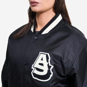 AlphaStyle Barren Varsity Jacket in Black – Nahaufnahme am Model mit AS-Chenille-Patch und Kontrastkragen