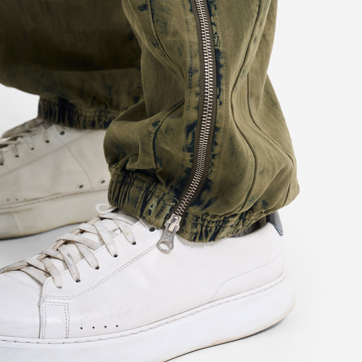 AlphaStyle Eames Cargo Pants in Army Green – Detailaufnahme des Beinabschlusses mit geöffnetem Reißverschluss über dem Sneaker