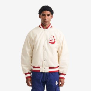 AlphaStyle Barren Varsity Jacket in Bone – Frontansicht am Model mit rotem AS-Chenille-Patch