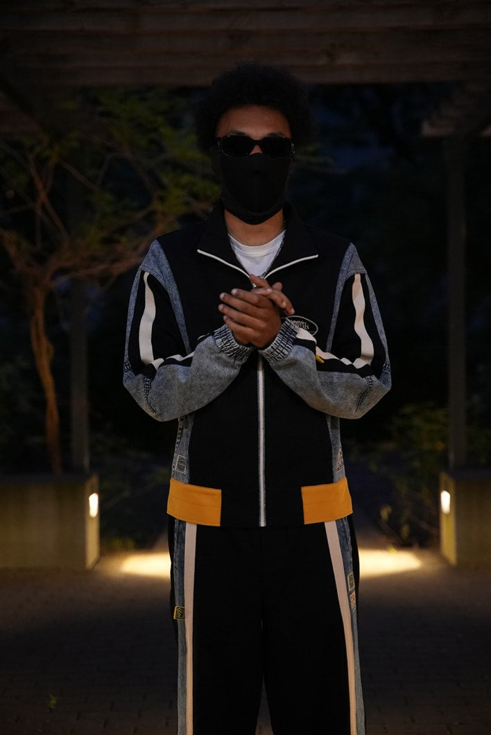 AlphaStyle Lincoln Track Jacket und Chase Track Pant in Black – Model im kompletten Set mit Denim-Einsätzen und senfgelben Kontrastbündchen